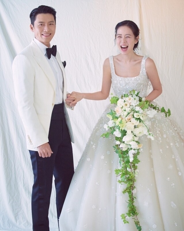 另一張婚紗照,玄彬依舊是選穿了 Tom Ford 西裝,而孫藝珍則換上了 Elie Saab 2022 春夏婚嫁系列的珠片長裙,仙氣十足。 另一張婚紗照,玄彬依舊是選穿了 Tom Ford 西裝,而孫藝珍則換上了 Elie Saab 2022 春夏婚嫁系列的珠片長裙,仙氣十足。