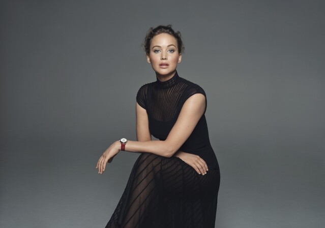 Jennifer Lawrence 身穿黑色透視連身裙，並戴上紅色的 LONGINES MASTER 名匠系列月相腕表
