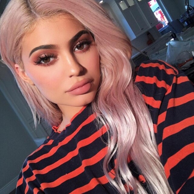 原本是黑髮的 Kylie Jenner 早前先染了一頭金髮，引來極大關注。幾日後，她把頭髮加上帶粉又帶橙調的蜜桃色，這個髮色令小麥色皮膚的她顯得白晢起來。