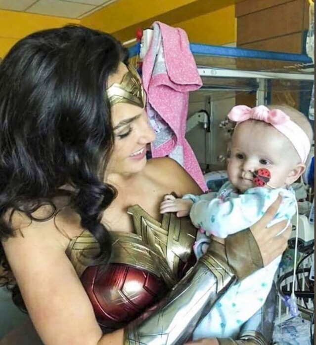 Gal Gadot 手抱着嬰兒，流露出甜美的笑容，為病童帶來溫暖。