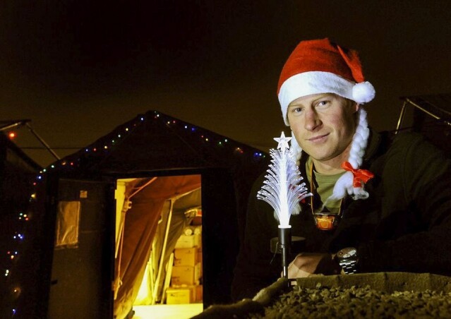 哈里王子頭戴聖誕帽現身在 Camp Bastion 的帳篷外面。