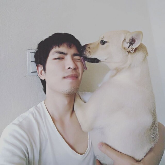 蕭敬騰的愛狗在舔他的臉。