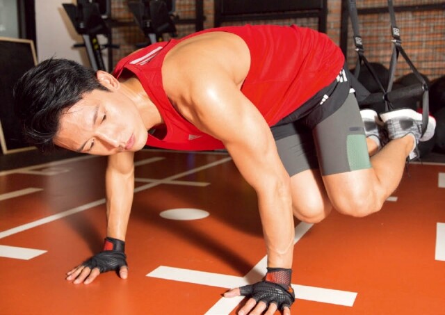 關智斌 Kenny 利用 Recoil S2 系統，訓練二頭肌及側腹肌肉。