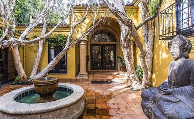 大門前放置了一個被樹木包圍的小型噴泉，為整個房屋增加了一絲神秘感。