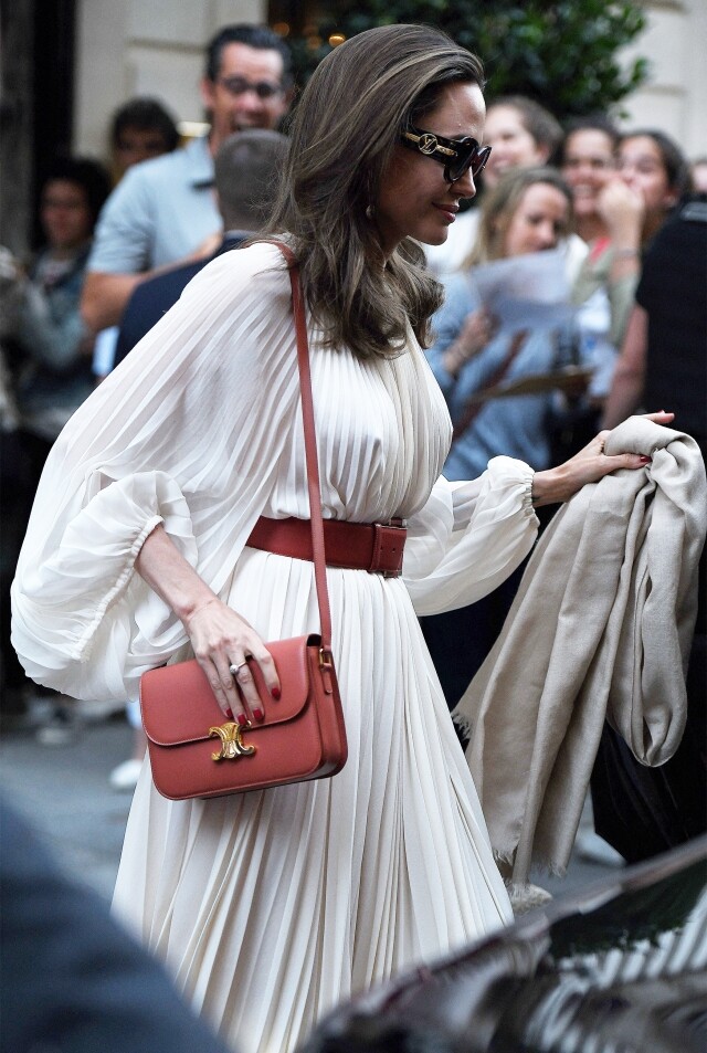 Angelina Jolie 則以白色連身裙，配襯 Celine Triomphe Bag ，盡顯大氣優雅一面。