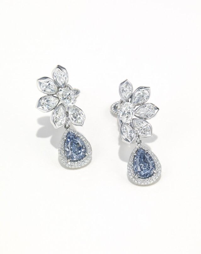 至於另一對分別鑲嵌 3.06 克拉和 2.61 克拉豔彩藍鑽和鑽石耳環，它的珍貴之處在於能夠將兩枚相似的藍鑽配對成一對耳環