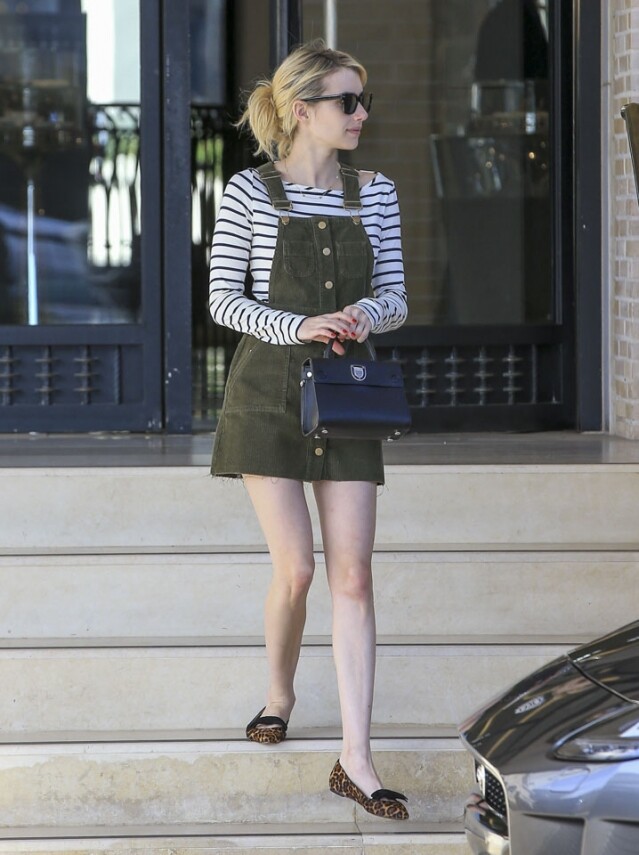 Emma Roberts 穿上墨綠色工人短裙，露出白滑雙腿，營造修長的視覺效果，並配搭一對豹紋平底鞋，活潑的個性表露無遺。