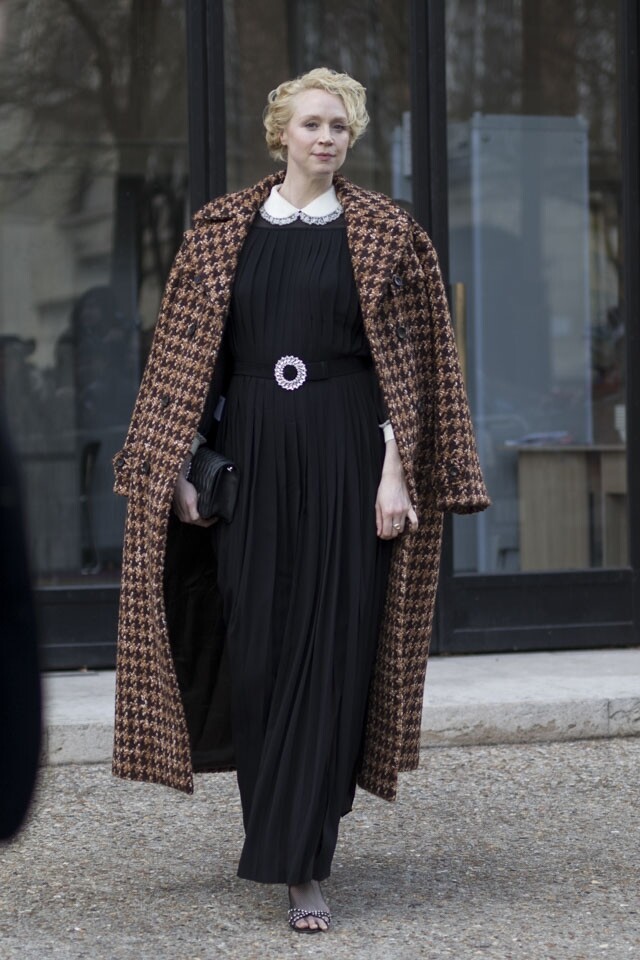 Gwendoline Christie 穿上黑色連身裙，外披啡色千鳥格的大褸，塑造出她優雅知性的一面。