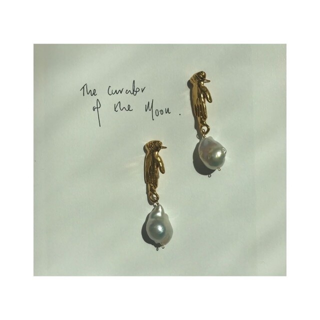 當中的一款珍珠首飾以「Curator Of The Moon」命名。以金銅打造成一雙手，連接著一雙不規則形狀的珍珠，反而成就了獨特的缺憾美。Rosh Mahtani 形容不規則的珍珠為 Sicilian bleeding hearts。