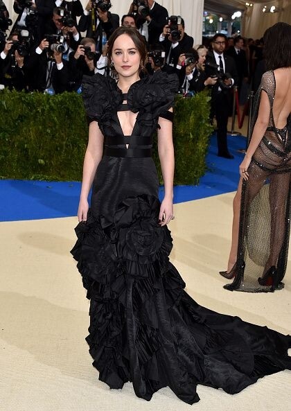在Met Gala的慈善晚宴上，Dakota Johnson以Gucci黑色花朵荷葉禮服晚裝出席