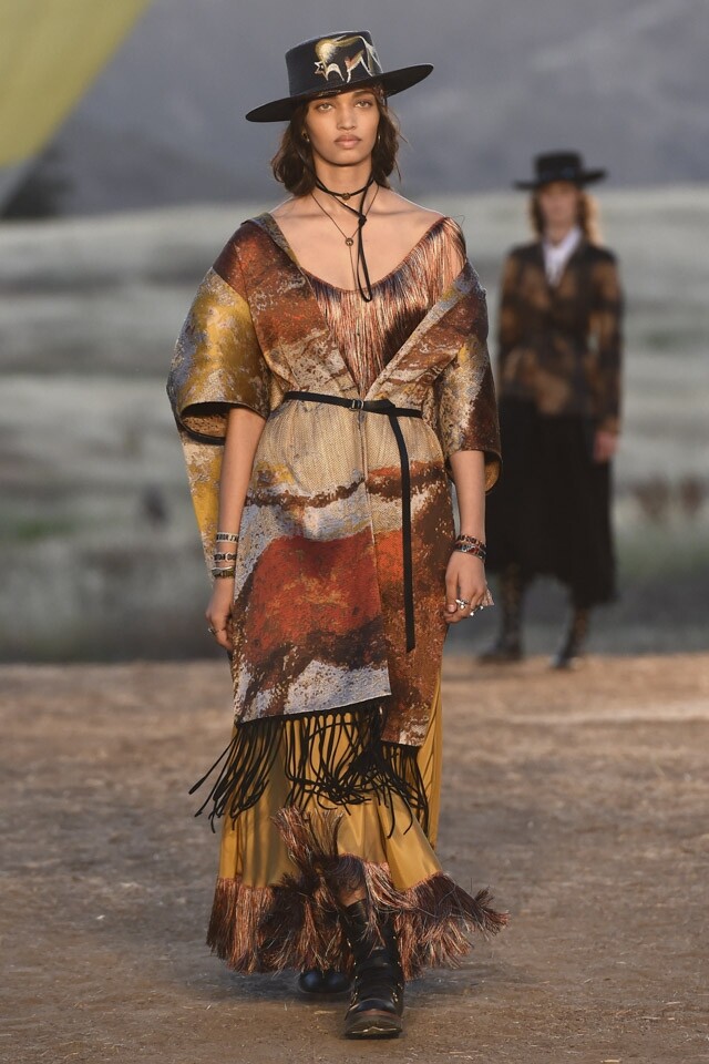 Ponchos 大熱回歸 猶如披肩般的 Ponchos 於 Dior 2018 早春系列中是亮點之一，綴上印花圖案或是流蘇設計，為系列增添了自由、敢於探險的精神。