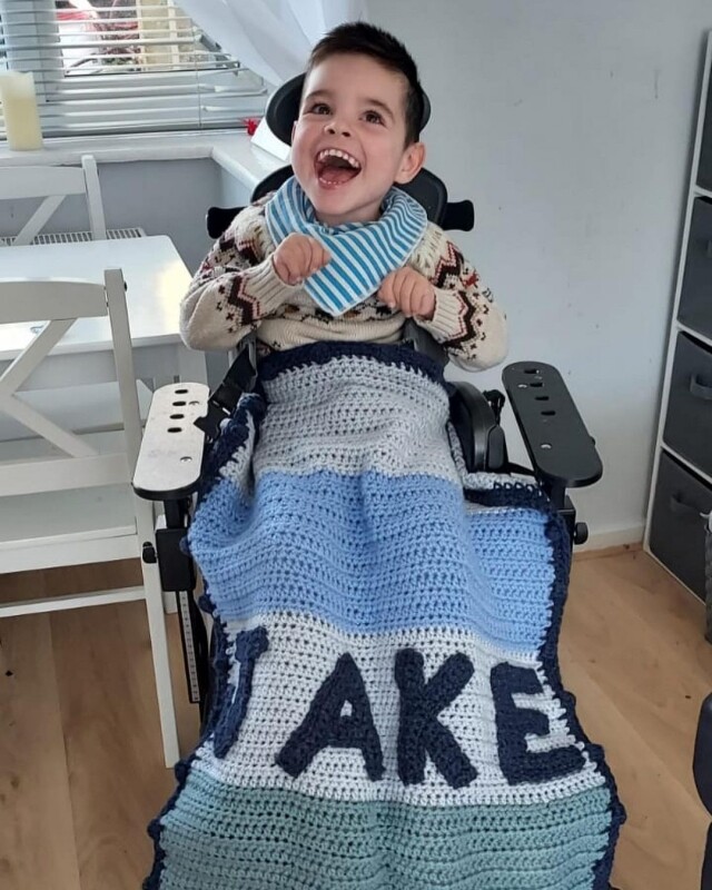 Tom 亦親自為一個患有極罕見神經系統生命受限疾病的男孩 Jake ，縫製繡下 JAKE 一字的針織被。