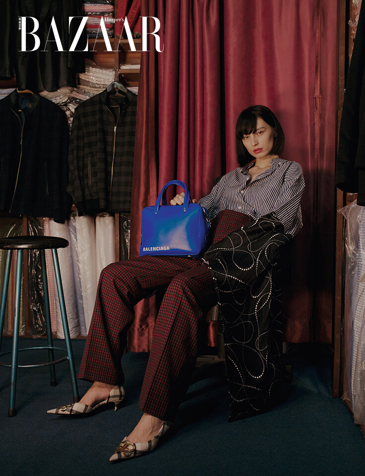 BALENCIAGA 條紋恤衫連圖案水袖、格紋高腰西褲、格紋尖頭鞋及標誌皮革手挽袋。